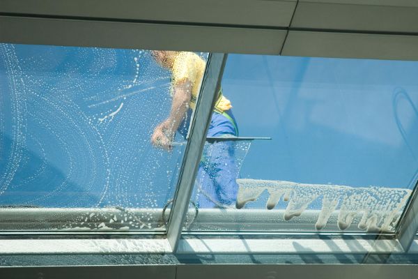 worker cleaning windows torquay